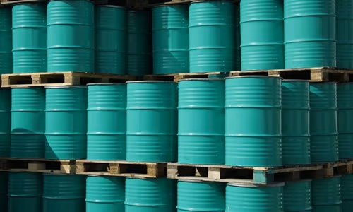 Butoaie turcoaz stivuite într-un terminal de produse petroliere